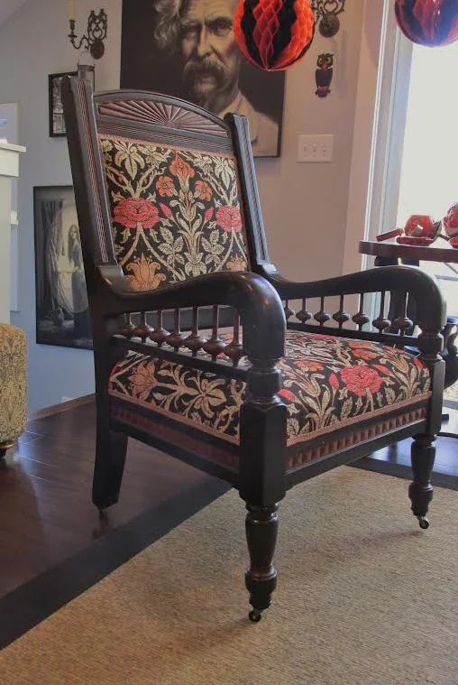 The same Eastlake armchair finished in a black and rust Morris botanical tapestry on brass casters